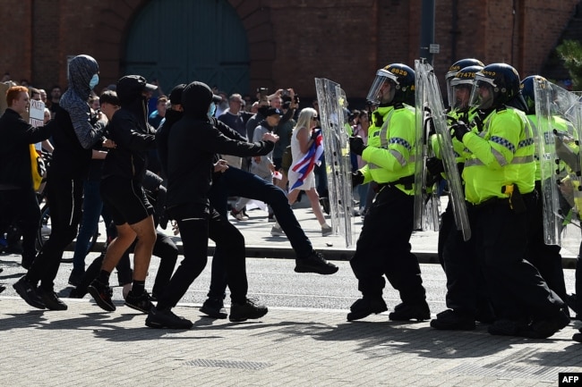 Oficerët e policisë përballen me protestues në Liverpul, Angli, më 3 gusht 2024, gjatë një proteste të mbajtur kundër sulmit me thikë në Southport, më 29 korrik. Europe Invasion sugjeroi rrejshëm se sulmuesi ishte një “imigrant mysliman”, ndërsa shefi i policisë së Londrës deklaroi se trazirat ishin “nxitur nga dezinformimi”.